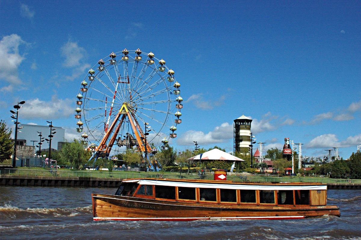 Barco no rio de Tigre com a roda-gigante ao fundo